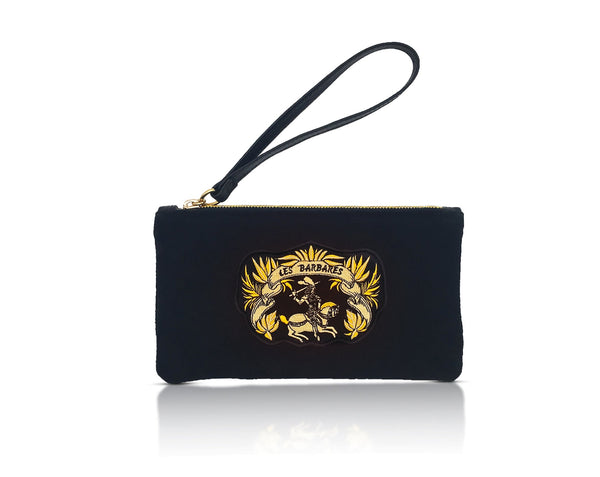 Black suede clutch handbag with gold embroidery patch of the Les Barbares logo. Gold wreath with an amazon on a horse and her sword above her head. detachable leather wristlet, zipper running across the top