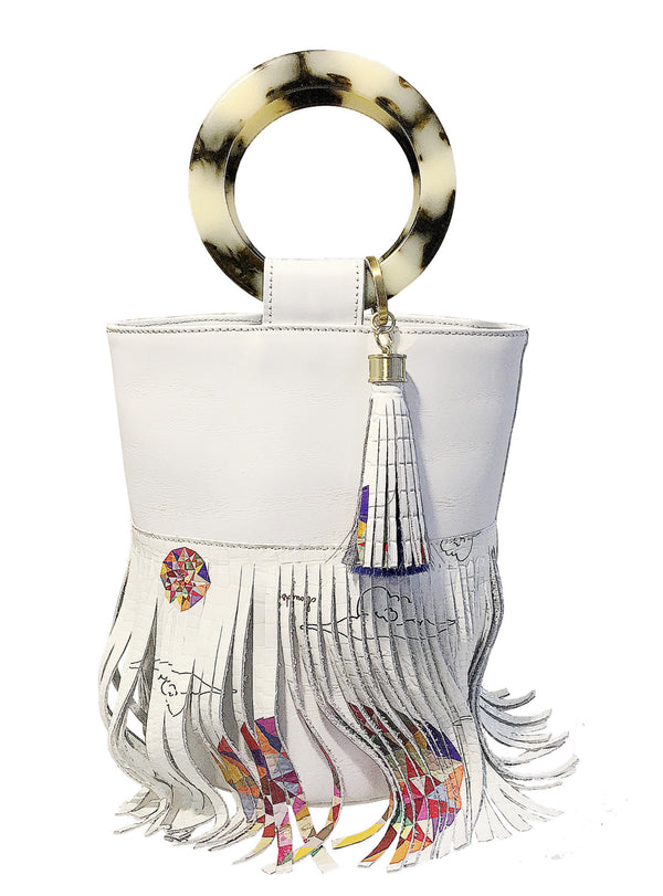 White leather bucket handbag with round resin handles and a leather skirt with the symmetrical colors and clouds design printed on the leather with a matching leather tassel attached to the handle
