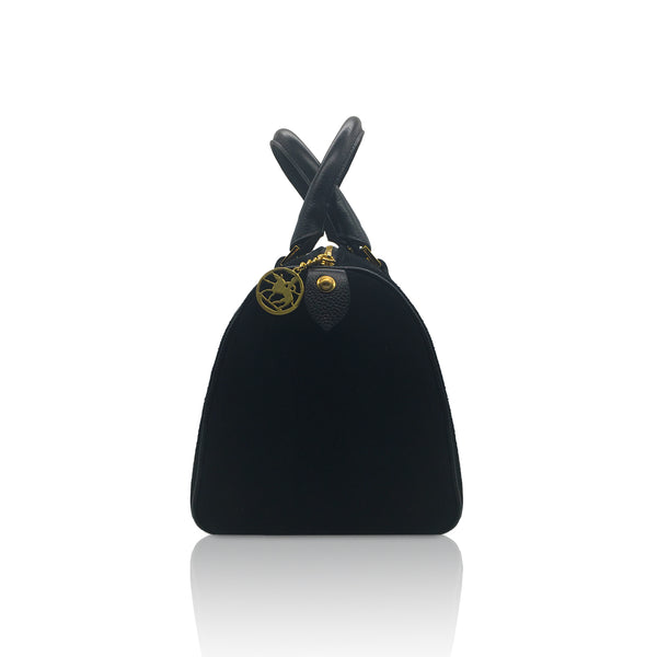 side view of black suede mini handbag with brass rivets leather handles and gold logotype zip fastener
