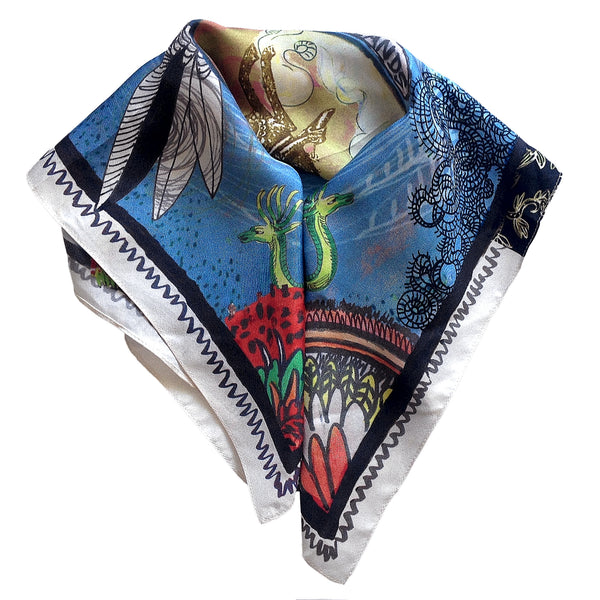 Printed blue 100% silk scarf folded to show the details of the images printed on the scarf