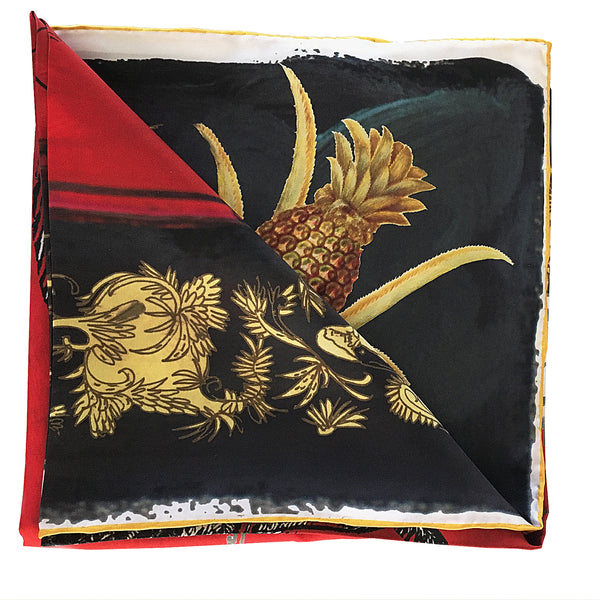 Folded mini 100% silk red, black and gold scarf showing the detail of the golden pineapple