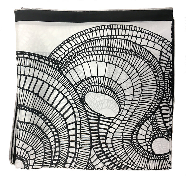 close up of the details of the spirals on the black and white 100% silk scarf