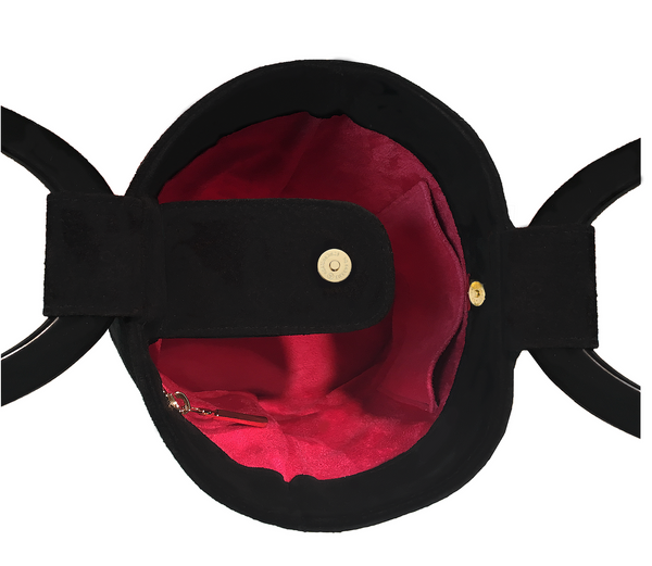Showing the inside of the black suede bucket bag with a raspberry pink suede interior and inside pockets one with a zipper and stud pression button to close the bag