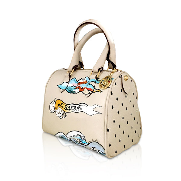 side view of Beige soft Italian leather mini handbag, with hand painted designs in blue, gold and white  by artist Marielle Plaisir.